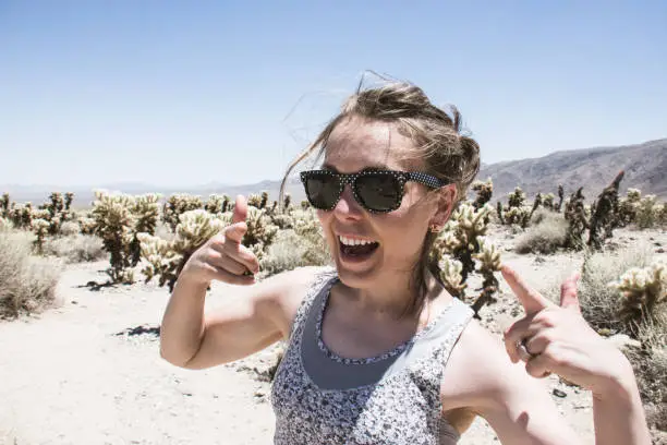 Adult female smiles among a field of Cholla Cactus in Joshua Tree National Park