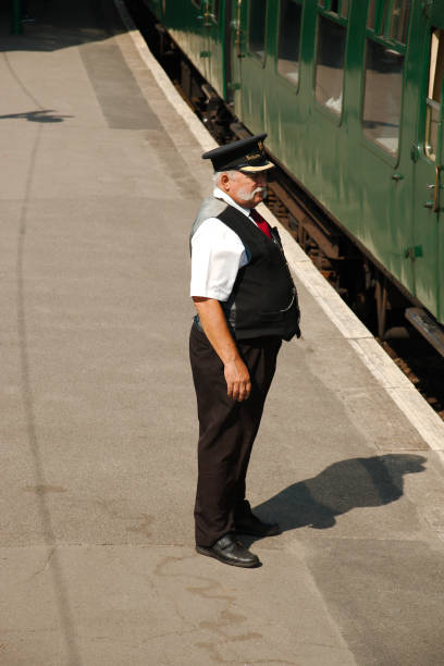 Corfe Castle, Dorset, UK - 3rd September 2018. Train guard or Station Master in period uniform on the station platform. Part of the Swanage steam railway.