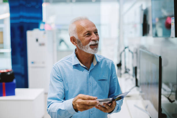 istock Beautiful senior man portrait at tech store. 1054439442