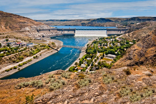 Grand Coulee Dam Grand Coulee Dam is a concrete dam on the Columbia River built to generate hydroelectric power and provide irrigation water. The dam and original two powerhouses were constructed between 1933 and 1942. Power from the dam fueled the growing industries of the Pacific Northwest in the 1940’s and 1950’s and also helped win World War II. Construction of the dam created Lake Roosevelt and forced the relocation of over 3,000 people including many Native Americans whose ancestral land was flooded. A third powerhouse was completed in 1974 making Grand Coulee Dam the largest power station in the United States. Grand Coulee Dam was photographed from Crown Point at Crown Point State Park near Grand Coulee, Washington State, USA. jeff goulden environmental conservation stock pictures, royalty-free photos & images