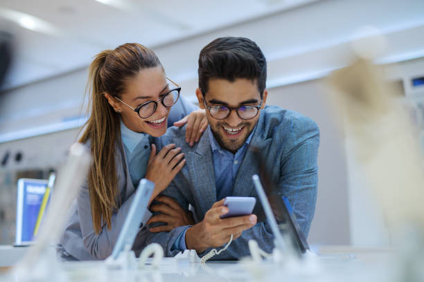 istock Couple at tech store looking for a new mobile phone. 1054443448