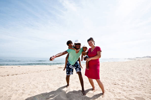 istock Young Family Posing On Beach Sand 1054447154
