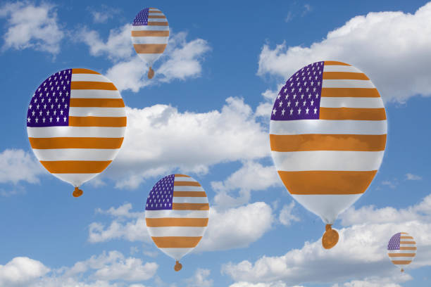 istock Inflatable balloons with USA flag in blue sky and clouds 1054447420
