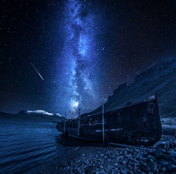 istock Old shipwreck and milky way with falling stars, Iceland 1054447704