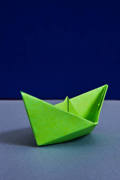 istock Green paper boat 1054454436