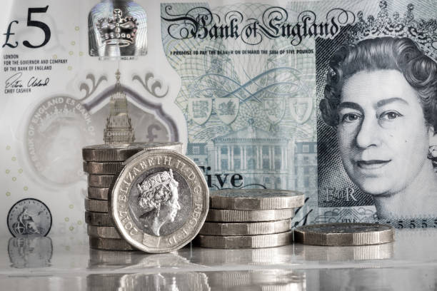1 ポンド硬貨は 3 つの山と 5 ポ��ンド紙幣に積み上げられました。 - one pound coin coin currency british culture ストックフォトと画像