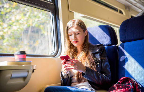 istock Woman in train using smart phone 1054485690