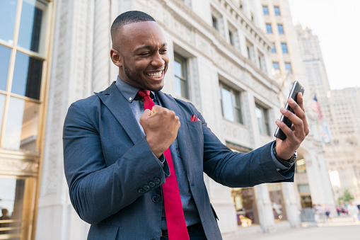 Businessman shooting selfie with phone in a successful winner pose