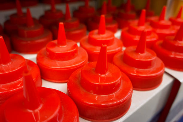 istock White colored Plastic bottles with red screw caps in store. 1054495722