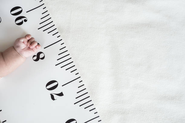 istock Baby hand and measuring tape. 1054513176