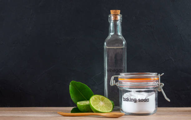 istock Baking soda with lemon on wooden on black background 1054551850