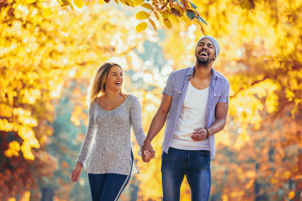 istock Young mixed couple walking in the autumn park 1054560732