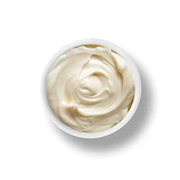 A small bowl of Mayonnaise isolated on a white background top down view from above