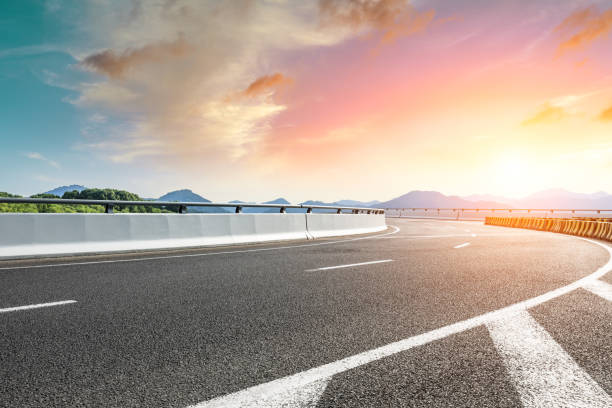 istock Empty asphalt road and beautiful mountain at sunset 1054589768