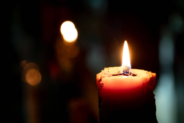 istock Candles burning in the dark night  with focus on single candle in foreground 1054589770