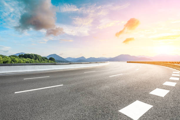 istock Empty asphalt road and beautiful mountain at sunset 1054589832
