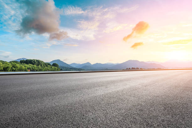 istock Empty asphalt road and beautiful mountain at sunset 1054590958