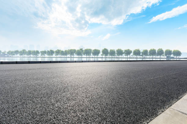 istock Asphalt road and beautiful trees with lake under the blue sky 1054596628