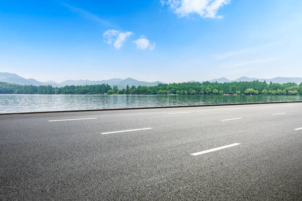 istock Asphalt road and beautiful mountain with lake under the blue sky 1054598524