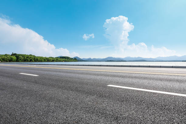 istock Asphalt road and beautiful mountain with lake under the blue sky 1054602582