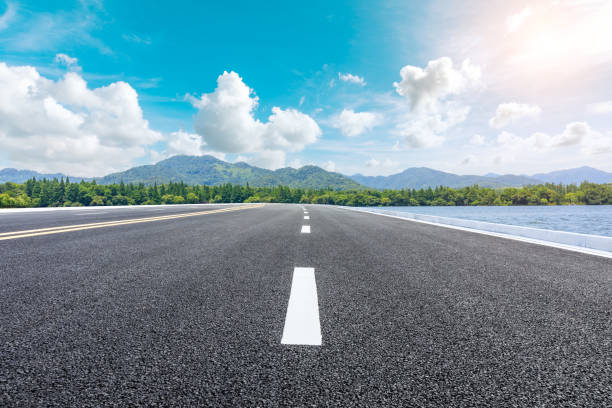istock Asphalt road and beautiful mountain with lake under the blue sky 1054602792