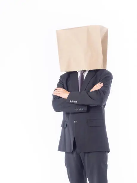 Photo of business person concept.blank space paper bag over head businessman in suit and black necktie with white background isolated.