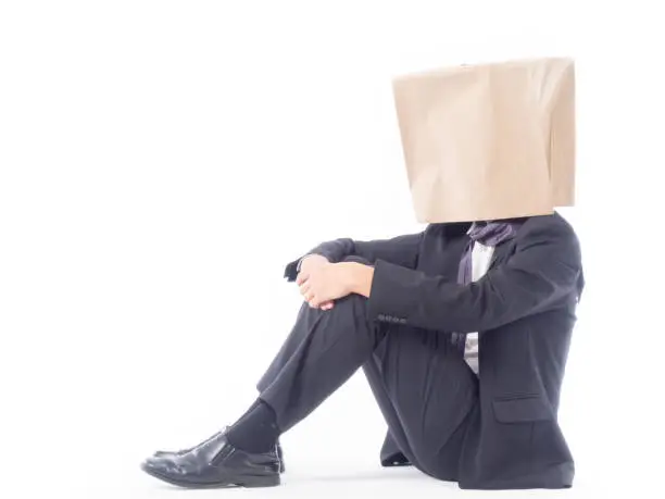 Photo of business person concept.blank space paper bag over head businessman in suit and black necktie with white background isolated.