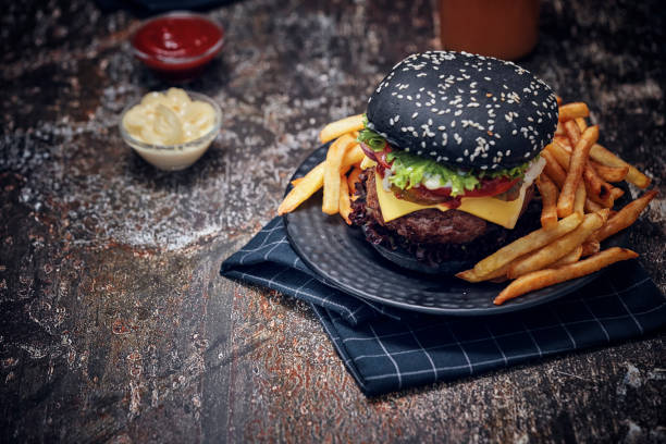 istock Black Burger Buns with Beef Pattie, Cheese, Tomato and Lettuce 1054612508
