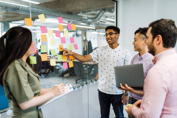istock Successful diverse business team putting sticky notes on glass 1054616470