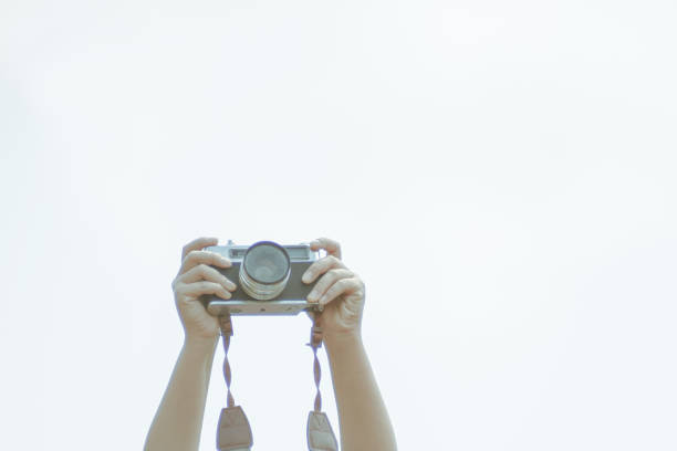 Camera is a tool for my impressive memories,Hold the camera up in the white sky.