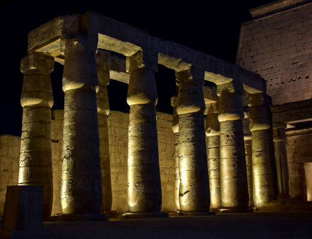 istock Ancient Egyptian Pharaohs Monuments of luxor temple with hieroglyphs writing craved on it  at night 1054618578