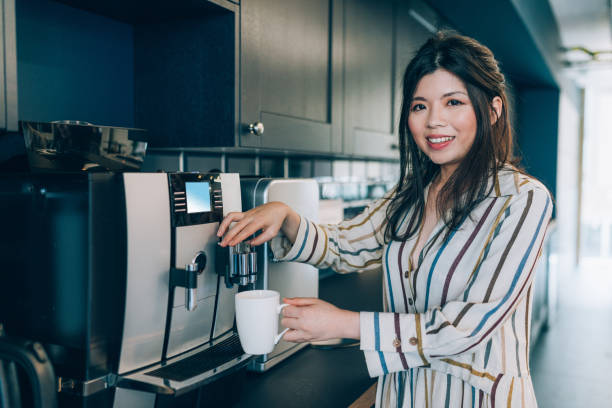 Businesswoman making coffee during coffee break