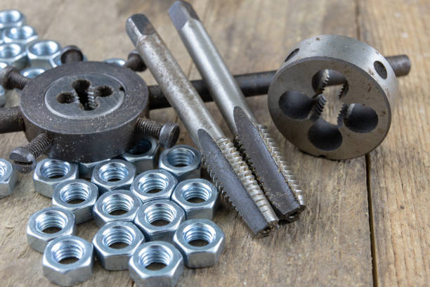 istock Dies and tap for thread cutting in locksmith works. Accessories for a mechanic. Dark background. 1054626512