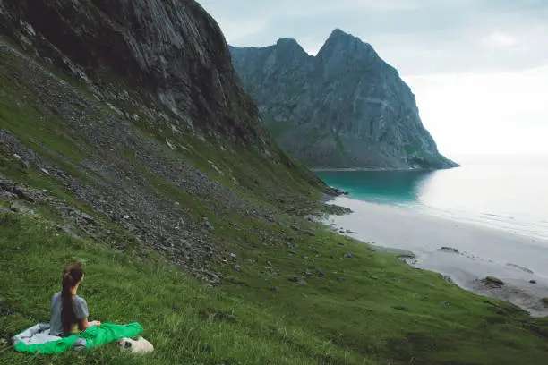 Photo of Woman and dog camping on Kvalvika beach in Norway