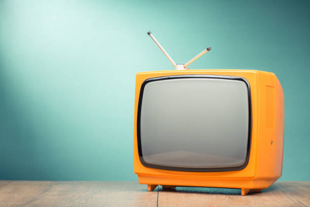 istock Retro old orange TV receiver on the table front textured gradient mint green background. Vintage style filtered photo 1054649788