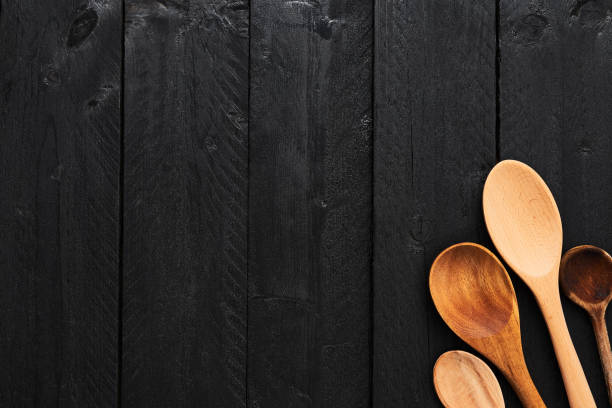 istock Wooden spoons on black wooden background. 1054649812
