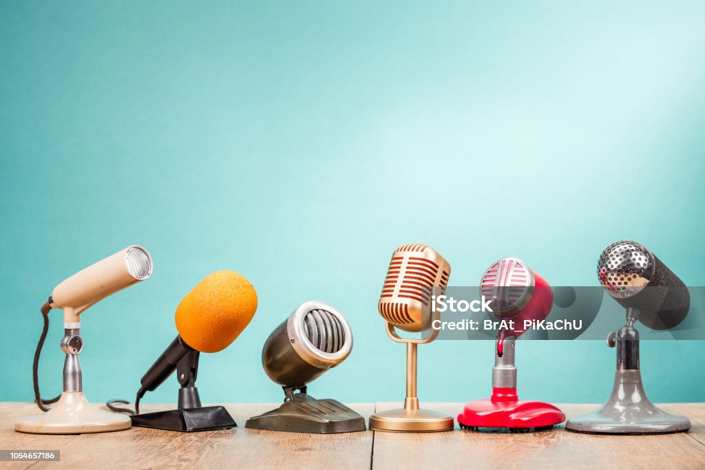 Retro old microphones for press conference or interview on table front gradient aquamarine background. Vintage old style filtered photo The Media Stock Photo