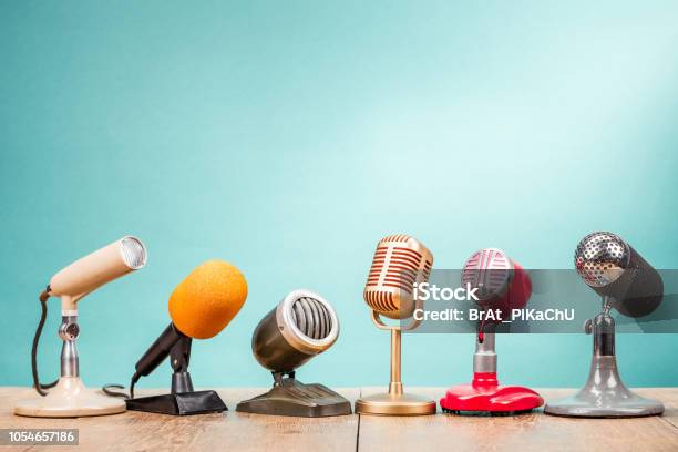 Retro Old Microphones For Press Conference Or Interview On Table Front Gradient Aquamarine Background Vintage Old Style Filtered Photo Stock Photo - Download Image Now