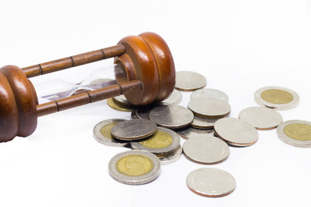 istock hourglass and coins close-up. Business background 1054663248