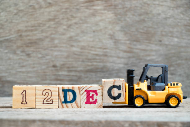 istock Toy forklift hold block c to complete word 12dec on wood background (Concept for calendar date 12 in month December) 1054672816