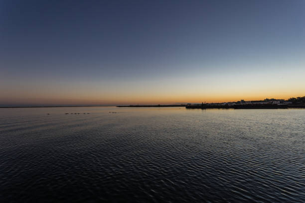 Sunrise over lake and industrial area with clear sky
