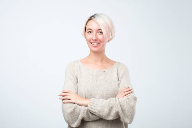 istock Confident and beautiful young woman looking at camera and smiling while standing against grey background 1054676728