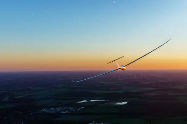 Glider flies a left circle into the sunset