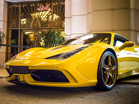 MACAU - NOVEMBER 12, 2014: Yellow Ferrari 458 Spider parked in front of casino entrance