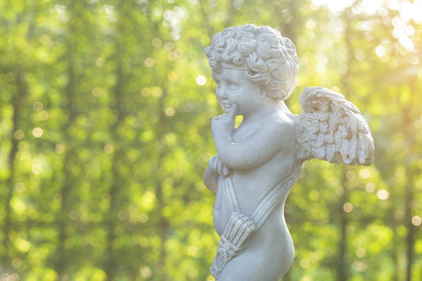 istock Cupid sculpture on green background in the garden 1054685980