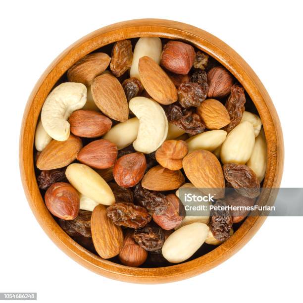 Nuts And Raisins In Wooden Bowl Over White Stock Photo - Download Image Now - Nut - Food, Variation, Bowl