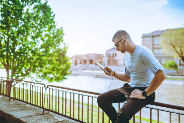 istock man listening to music by the river 1054686372