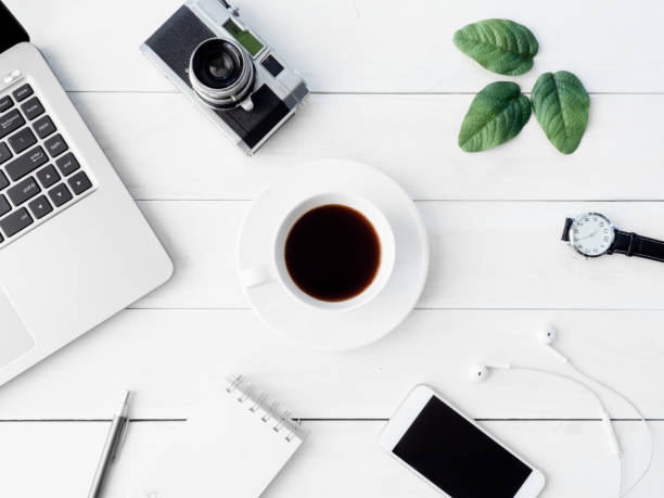 istock top view of office desk workspace with coffee cup, notebook, plastic plant, smartphone and keyboard on white background, graphic designer, Creative Designer concept. 1054689668