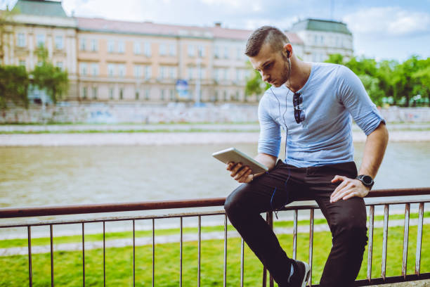 istock man listening to music by the river 1054689742