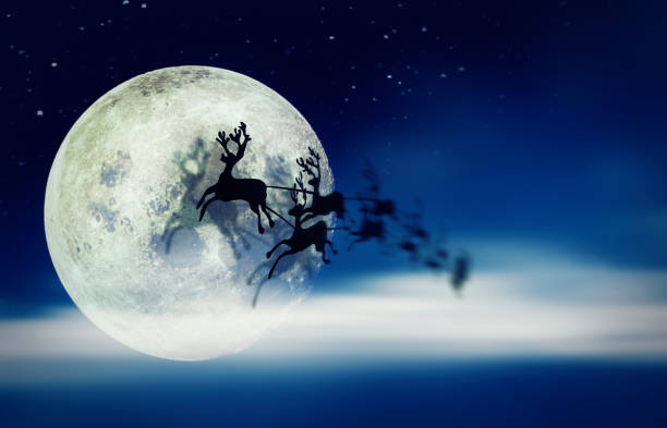 istock Santa Claus Sleight and Reindeers Silhouette Flying over the Moon 1054692932
